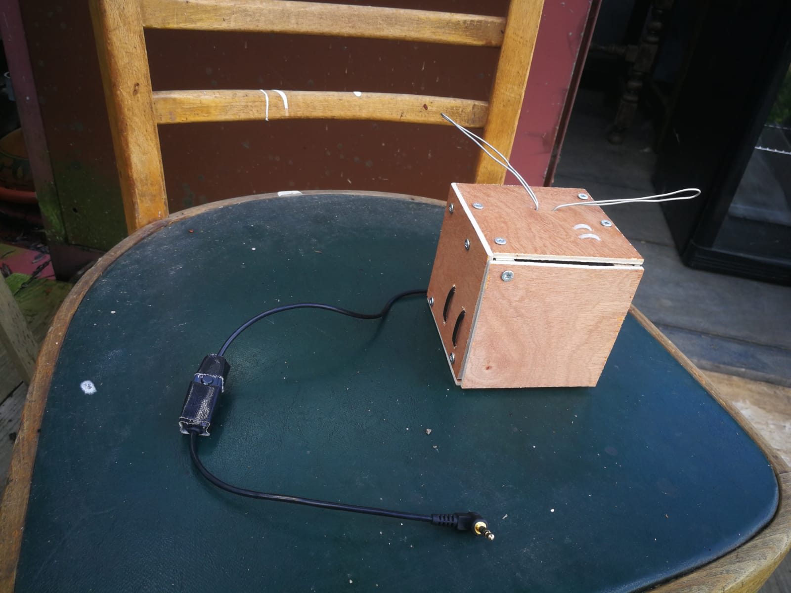 een mini-radiootje van hout ligt op een stoel